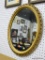 GOLD TONED MIRROR; OVAL FRAMED MIRROR WITH PIERCED EDGING. MEASURES 20 IN X 24 IN