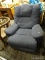 BLUE RECLINER; FEATURES A TEXTURED BLUE UPHOLSTERY AND A WOODEN RECLINER LEVER. MEASURES