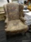 FLORAL WINGBACK ARM CHAIR; FEATURES A DARK BEIGE UPHOLSTERY WITH PINK AND BLUE FLORAL DESIGNS.