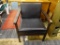 MID CENTURY MODERN SIDE CHAIR; WOODEN CHAIR UPHOLSTERED IN FAUX BLACK LEATHER. SITS ON FOUR SQUARE