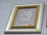 FRAMED PRINT OF WHITE FLOWERS IN A VASE; IN A GOLD AND SILVER TONED FRAME AND MEASURES 13 IN X 16 IN