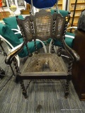 DARK STAINED WINGBACK CHAIR; FEATURES SPIRAL TURNED SPINDLES, A CIRCULAR WOVEN BACK AND SEAT, AND A