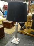 METAL TABLE LAMP; BLACK LINEN BELL SHAPED SHADE SITTING ON A BRUSHED SILVER TONED COLUMN STYLE BODY