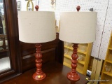 PAIR OF TABLE LAMPS; EACH LAMP HAS A LINEN DRUM SHAPED SHADE SITTING ON A BRUSH RUST RED COLORED