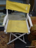 DIRECTORS CHAIR; FEATURES A WHITE WOODEN FRAME WITH YELLOW UPHOLSTERY. COLLAPSES FOR EASY STORAGE.