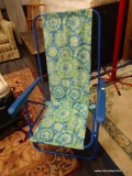 TIE-DYE BEACH CHAIR; FEATURES A BLUE METAL FRAME, AND A BLUE AND GREEN TIE-DYE PRINT SEAT.