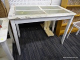 FARMCHIC TABLE; HAS 4 GLASS PANELS ON THE TOP AND A WHITE CHIPPY FINISH. IS IN GOOD USED CONDITION