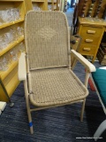 TAN FOLDING OUTDOOR CHAIR; VINTAGE WOVEN CHAIR. TAN IN COLOR WITH PLASTIC ARMRESTS. MEASURES 23.5 IN