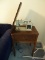 (UPLR) SEWING MACHINE; IN A MAHOGANY CABINET AND MADE BY CAPITOL. WITH LIFT LID OPEN MEASURES 43 IN