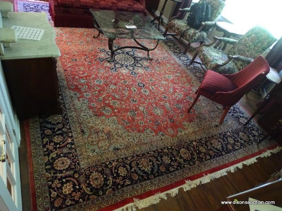 (LR) KASHAN AREA RUG; LARGE AREA RUG IN REDS, BLUE, IVORY, AND BLACK. HAS A FLORAL BORDER WITH