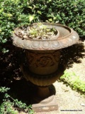 (OUT) CAST IRON URN PLANTER; HAS LIONS HEAD AND EMBOSSED FLOWERS DETAILING. MEASURES 19 IN X 25 IN