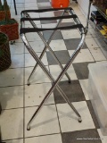 LUGGAGE VALET STAND; CHROME AND BLACK STRAP LUGGAGE STAND IN VERY GOOD CONDITION. FOLDS FOR EASY