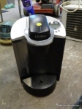 (GARAGE) KEURIG; KEURIG COFFEE MAKER IN GOOD USED CONDITION. HAS NOT BEEN TESTED