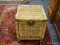 WICKER STORAGE CUBE; HAS A FALL FRONT DOOR WITH BRASS HARDWARE. IS ON WHEELS FOR EASY MOVEMENT. HAS