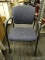 ROLLING OFFICE CHAIR; NAVY BLUE UPHOLSTERED BACK AND SEAT WITH TWO-TONED DOT DESIGN AND BLACK FRAME.