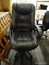 FAUX LEATHER OFFICE CHAIR; BLACK OVERSTUFFED BACK AND SEAT WITH PADDED ARMS AND BLACK SWIVEL FRAME.