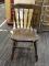 VINTAGE SPINDLE BACK CHAIR; DARK WOOD SPINDLE BACK CHAIR WITH SLIGHT SADDLE SEAT. SITS ON A SPINDLE