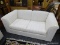 BAUHAUS LOVESEAT; OFF WHITE COLORED LOVE SEAT WITH BLUE AND GREY PINSTRIPES. THIS TWO CUSHIONED LOVE