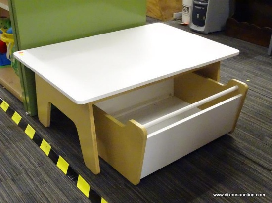 CHILD'S SIZE TABLE AND STORAGE BIN; RECTANGULAR WHITE TOP SITTIN ON A LIGHT COLORED WOOD GRAIN BASE.