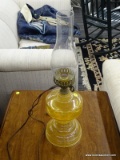 VINTAGE ELECTRIC OIL LAMP; CLEAR GLASS CHIMNEY SITTING ON AN AMBER GLASS OIL LANTERN BASE. MEASURES