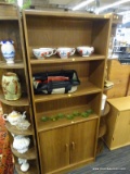 WOODEN BOOKCASE; HAS 3 UPPER SHELVES AND 2 LOWER DOORS WITH SPACES FOR ADJUSTABLE SHELVES. IS IN