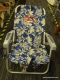 FOLD-OUT BEACH CHAIR; BLUE AND WHITE FABRIC SEAT WITH A FLORAL PATTERN.