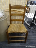 OAK SIDE CHAIR; HAS A LADDER BACK AND WOVEN SEAT. MEASURES 1 FT 5 IN X 1 FT 3 IN X 2 FT 8 IN