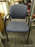 ROLLING OFFICE CHAIR; NAVY BLUE UPHOLSTERED BACK AND SEAT WITH TWO-TONED DOT DESIGN AND BLACK FRAME.