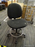 ROLLING OFFICE CHAIR; BLACK UPHOLSTERED PADDED BACK AND SEAT, SITTING ON A SWIVEL BASE WITH CHROME