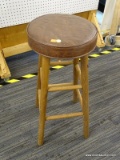 CUSHIONED BARSTOOL; ROUND BROWN VINYL SEAT SITTING ON WOODEN BASE WITH FOOT RESTS. MEASURES 2 FT 5.5