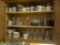(KIT) CONTENTS OF CABINET TO INCLUDE: GLASS DRINKING GLASSES, VARIOUS COFFEE MUGS, GLASS PLATES,