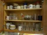 (KIT) CONTENTS OF CABINET TO INCLUDE: GLASS DRINKING GLASSES, VARIOUS COFFEE MUGS, GLASS PLATES,