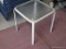 (OUT) GLASS TOP PATIO SIDE TABLE; SQUARE PATIO SIDE TABLE WITH FROSTED GLASS TOP SITTING ON A CREAM
