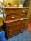 CHEST OF DRAWERS; RICH WOODGRAIN 2 OVER 3 CHEST OF DRAWERS WITH DOVETAIL DRAWERS AND WOODEN PULLS.