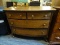 VICTORIAN MIRRORED DRESSER; OVAL SHAPED MIRROR ON A ROTATING WOODEN BASE SITTING ATOP A 2-OVER-2