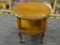 ROUND WOODEN SIDE TABLE; WOODEN SIDE TABLE WITH A ROUND TOP AND DETAILED EDGING. BELOW THE TABLE TOP