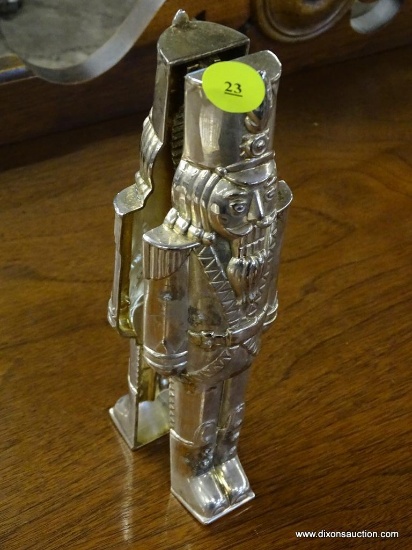 NUTCRACKER SHAPED METAL NUTCRACKER; CAN STAND ON ITS OWN. MEASURES 8 IN TALL.