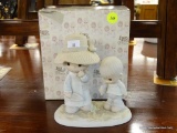 A PRECIOUS MOMENTS PORCELAIN FIGURINE; ENESCO 