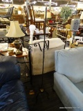 WROUGHT IRON FLOOR LAMP; BLACK POST WITH BRASS FINIAL AND CURLING ARM WITH LIGHT FIXTURE ON THE END.