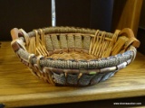 LARGE TWO-TONE BASKET; ROUND WOVEN BASKET WITH NATURAL FIBER DETAILING. HAS 2 WOODEN HANDLES.