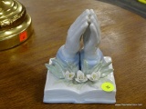 WESTMINSTER PORCELAIN PRAYING HANDS STATUE; PORCELAIN STATUE OF PRAYING HANDS BEHIND WHITE FLOWERS