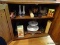 (LR) CABINET CONTENTS; CONTENT INCLUDES CANDLES IN BOXES, BRASS AND 2 MILK GLASS VASES, 2 ETCHED