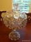 (DR) LARGE PRESSED GLASS LIDDED COMPOTE; HAS CUT STAR DETAILING. MEASURES 16 IN TALL X 10.25 IN