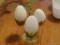 (DR) DECORATIVE MARBLE EGGS ON STAD; 3 WHITE MARBLE EGGS SITTING IN A 3 EGG CUP STAND.