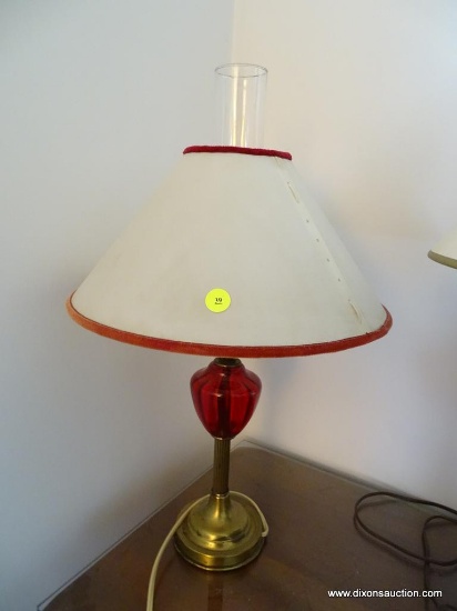 (LR) CRANBERRY GLASS TABLE LAMP; CRANBERRY GLASS TABLE LAMP SITTING ON A METAL STAND. COMES WITH A