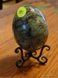 (DR) MARBLE EGG AND STAND; GREEN AND BLACK LARGE MARBLE EGG ON A BLACK STAND WITH SCROLLING LEGS.