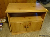 (DEN) OAK TV STAND; SMALL OAK TV STAND WITH A LOWER SHELF AND 2 CABINET DOORS WITH METAL KNOBS.