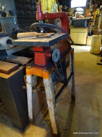 BAND SAW; MAYTAG WESTINGHOUSE BAND SAW. HAS A RED TOP MOUNTED ON A TABLE.