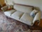 (FAM) ROLL ARM CAMELBACK SOFA; ANTIQUE CAMELBACK ROLL ARM SOFA WITH A BEIGE FLORAL FABRIC AND 4