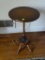 (FAM) SIDE TABLE; WOODEN SIDE TABLE WITH A LONG TAPERED LEG THAT LEADS TO A LOWER STOOL WITH 4